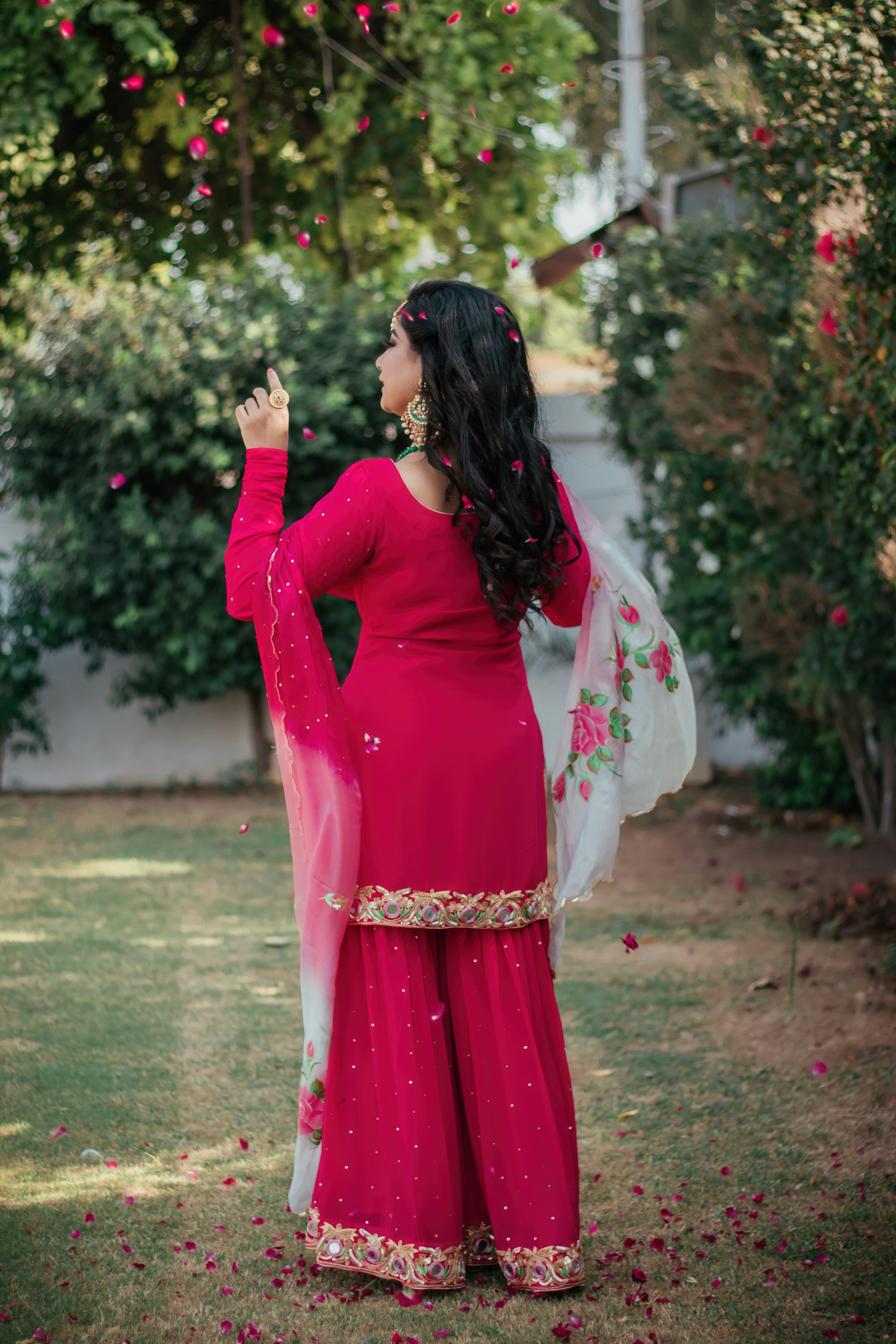 woman in red long sleeve dress standing on green grass field during daytime